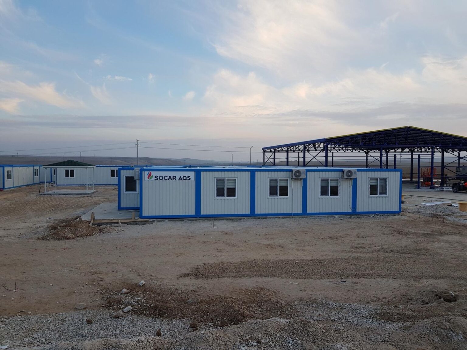 Şantiye kampı — konteyner sırası ve inşaat alanı
